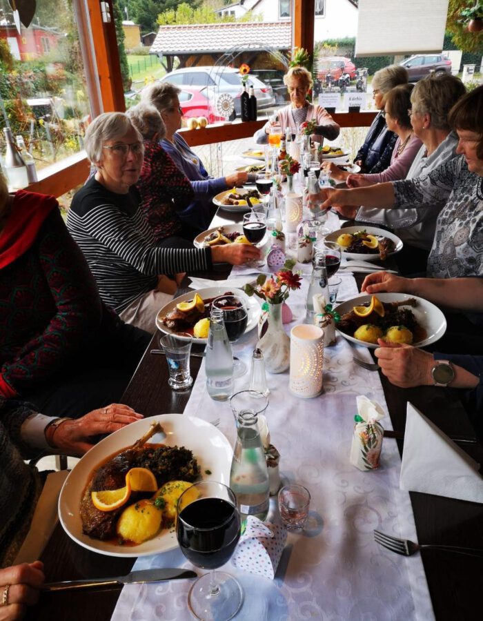 Gemeinsames Gänseessen an einer langen, festlich gedeckten Tafel