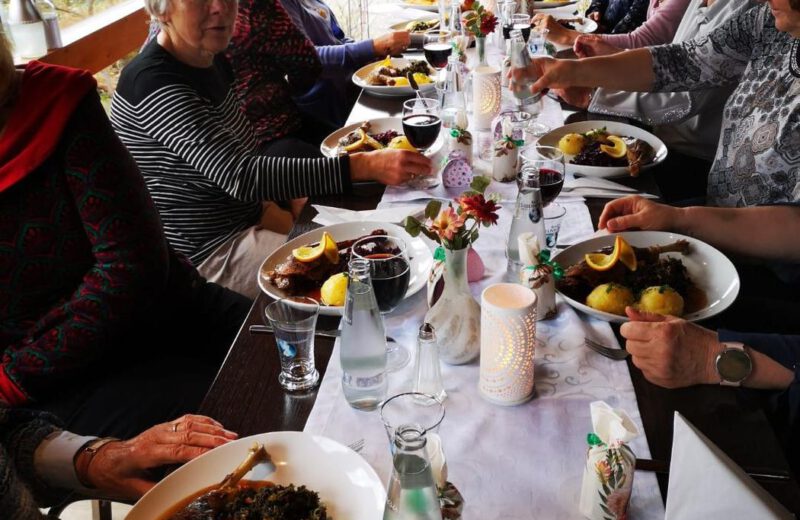Gemeinsames Gänseessen an einer langen, festlich gedeckten Tafel